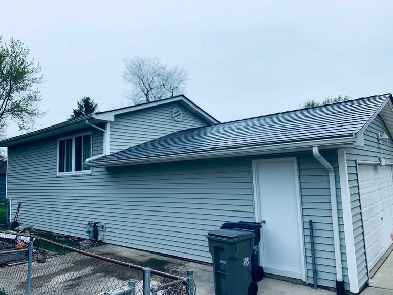 Deep Charcoal Interlock Slate aluminum roof on a two-storey home with a metal roof and white trim in a, Elgin, Illinois