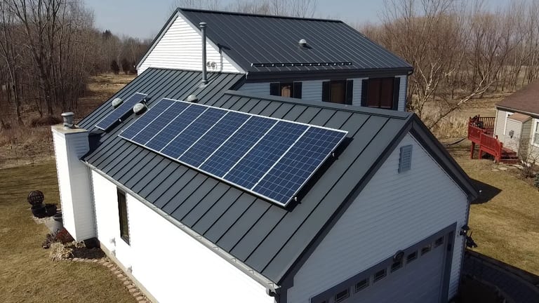 Deep Charcoal Interlock Standing Seam aluminum roof on a white modern home with a metal roof among bare trees, Carpentersville, Illinois