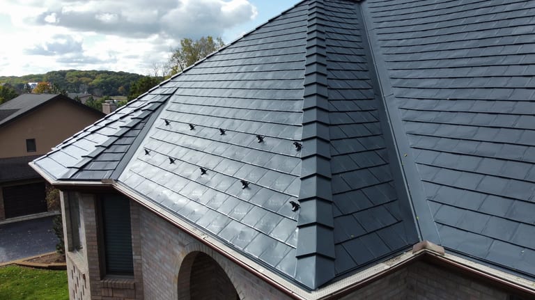 Black Interlock Slate aluminum roof on a brown one-storey home with a metal roof among green trees, Lemont, Illinois