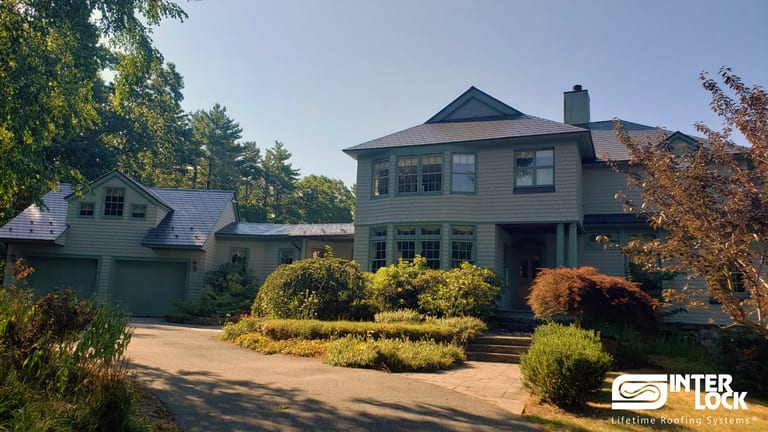 Two-story Colonial home in Beverly, MA with Interlock deep charcoal aluminum slate metal roofing, complex multi-hip roof, attached garage, and chimney.