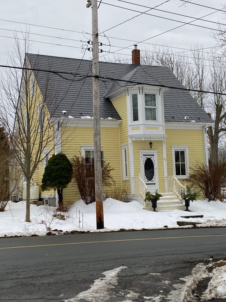 Charcoal Grey Interlock Slate aluminum roof on a yellow heritage home with a metal roof in Lunenburg, Nova, Lunenburg, Nova Scotia