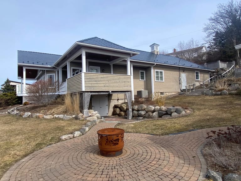 Deep Charcoal Interlock Slate aluminum roof on the home with chimney, Lunenburg, Nova Scotia