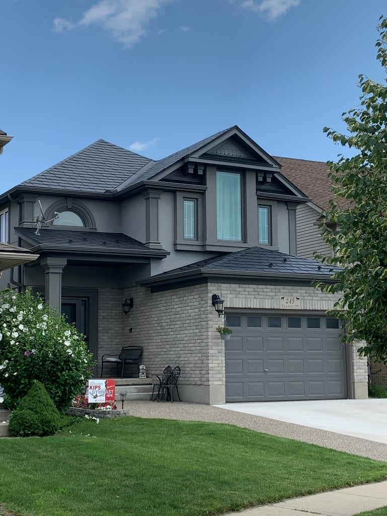 Two-storey Craftsman home in Cambridge ON with a black Interlock aluminum slate metal roof featuring complex multi-hip geometry and a front dormer.