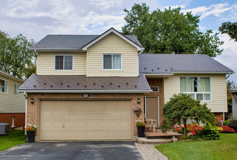 Two-storey suburban home in Shelburne ON with Interlock Tudor Brown aluminum slate metal roofing across multiple roof planes and gable.