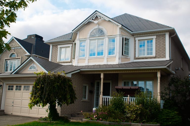 Two-storey Victorian-style home in Ajax, ON featuring Interlock aluminum slate roofing in Musket Grey with complex multi-hip roof and decorative dormer.