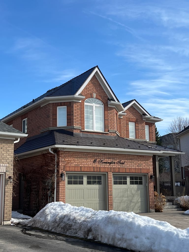 Two-storey brick Colonial home in Barrie, ON featuring Interlock Tudor Brown aluminum slate roofing with complex multi-hip profile and dormers.