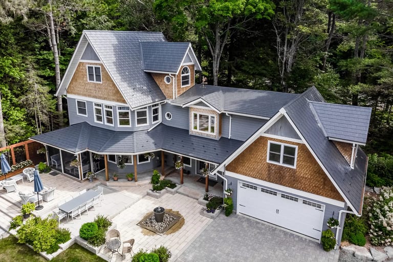 Aerial view of a Victorian-style home in Algonquin Highlands with a complex deep charcoal Interlock aluminum slate roof featuring dormers, turret, and multiple valleys.