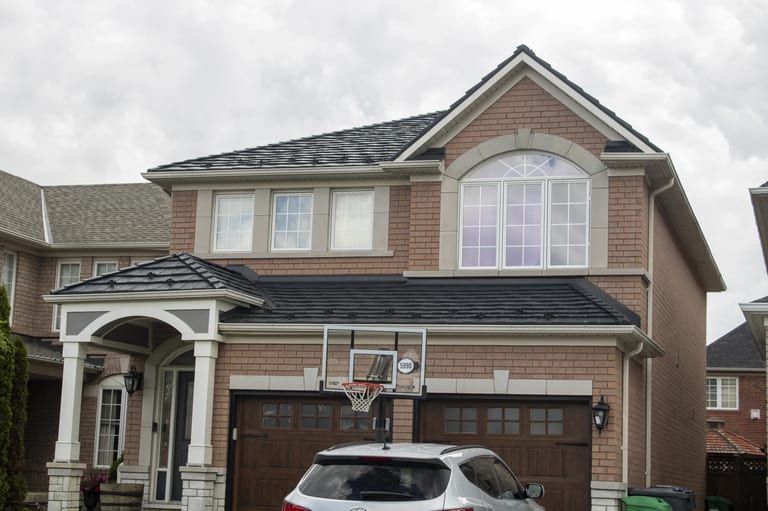 Black Interlock Shake aluminum roof on a brick two-storey home with a garage in a residential, Mississauga, Ontario
