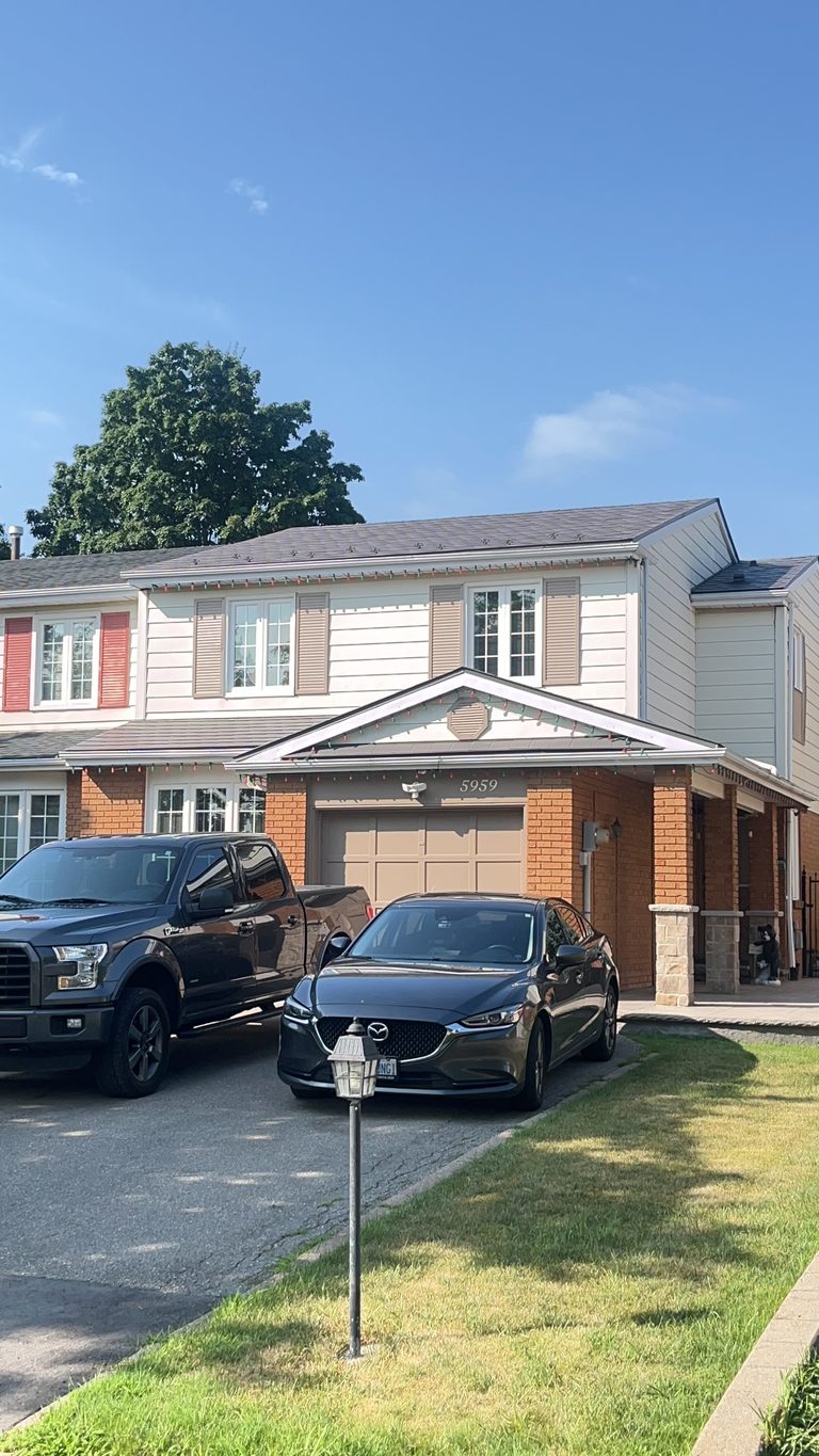 Front elevation of a two-storey townhome in Mississauga with Interlock Musket Grey aluminum slate metal roofing on a multi-plane gabled roof.