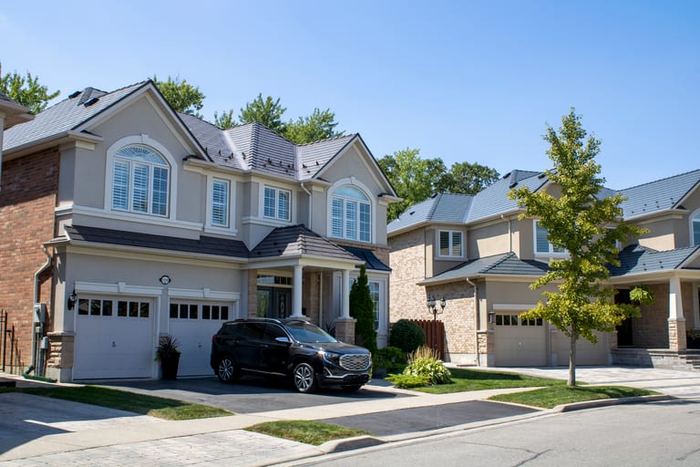 Two-storey Colonial-style homes in Milton, ON featuring Interlock Tudor Brown cedar shingle aluminum metal roofing with multi-hip complex roof profiles.