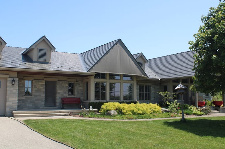 Musket Grey Interlock Cedar Shingle aluminum roof on a grey two-storey home with dormers in a suburban setting, Guelph, Ontario