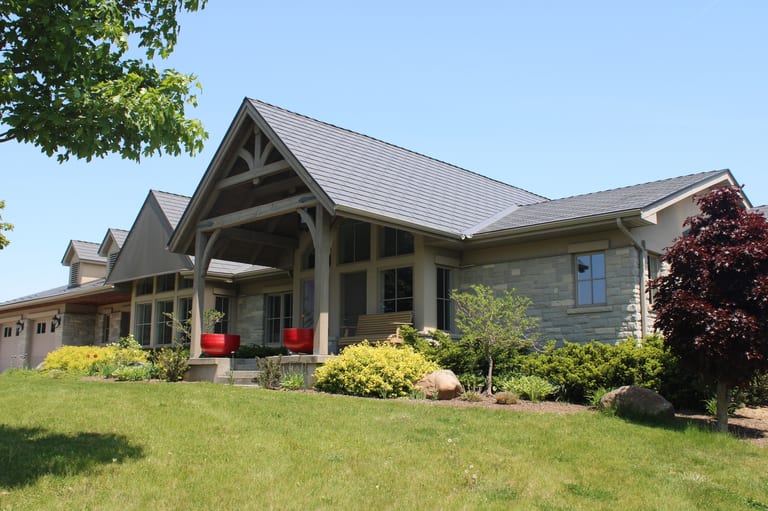 Musket Grey Interlock Cedar Shingle aluminum roof on a light grey home with a metal roof and large front windows, Guelph, Ontario
