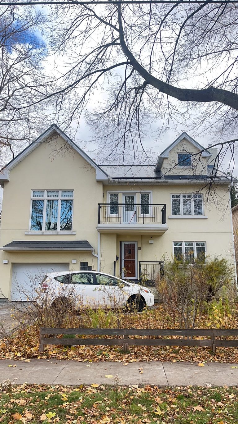 Front elevation of a 2-storey modern home in Etobicoke with deep charcoal standing seam metal roofing, dormers, and a second-floor balcony.