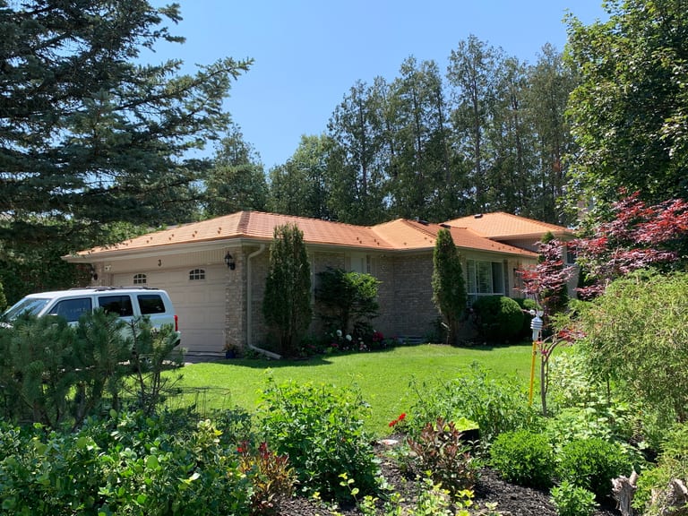 Single-storey ranch home in Aurora, ON with Interlock Copper Penny cedar-shingle aluminum roof over multi-hip roofline, surrounded by mature trees.