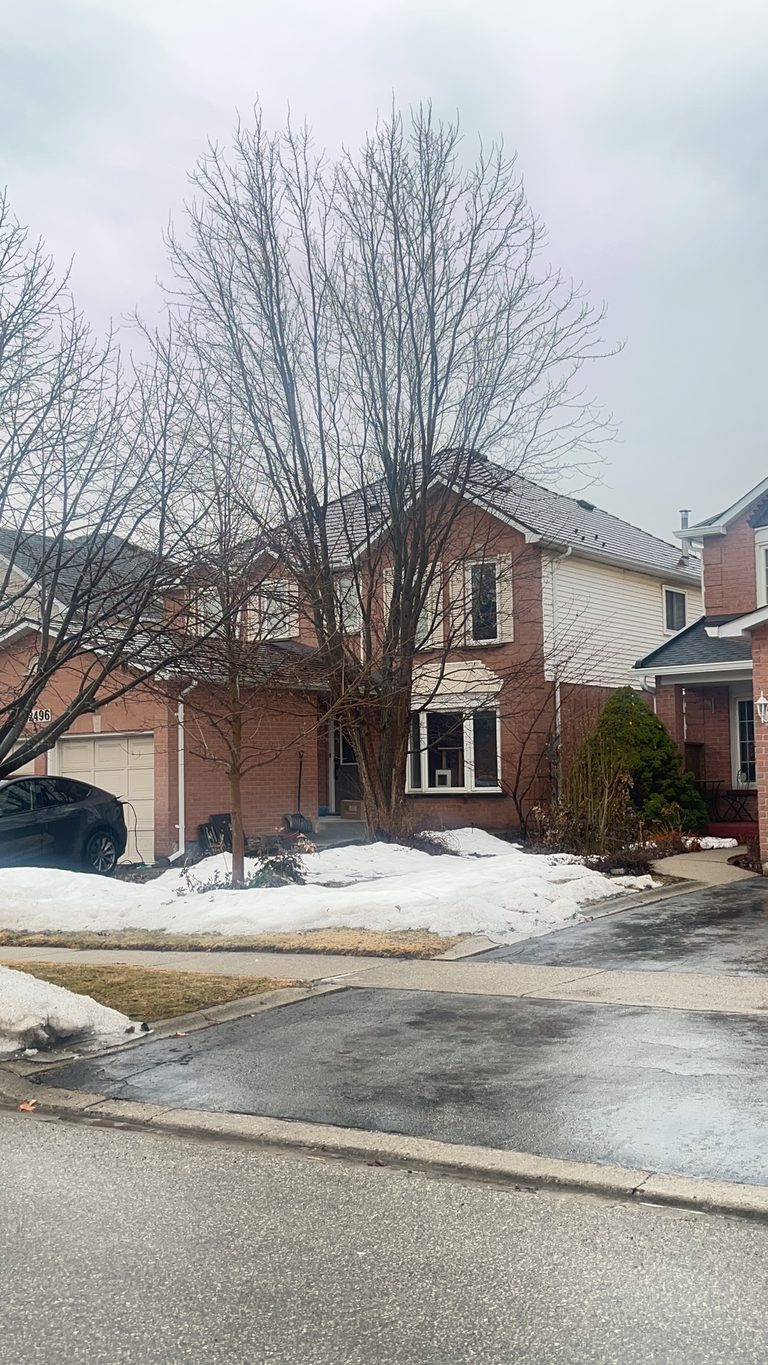 Two-storey brick Colonial home in Burlington ON with Interlock Cedar Shingle metal roof in Colonial Brown, viewed from across the street in winter.