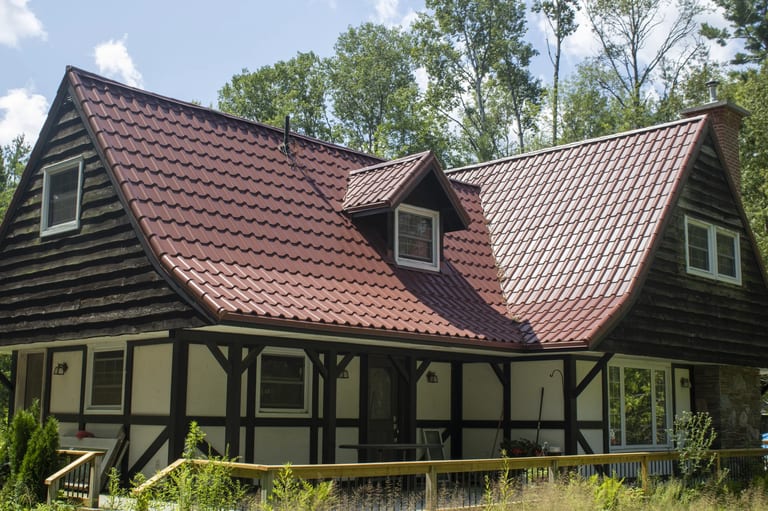 Tile Red Interlock Tile aluminum roof on a cottage with a red metal roof in a forested lakeside, Gravenhurst, Ontario
