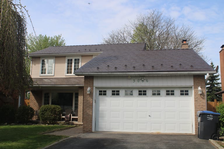 Two-storey Colonial-style home in Mississauga with Interlock aluminum cedar-shingle metal roofing in Colonial Brown, featuring snow guards and a brick chimney.