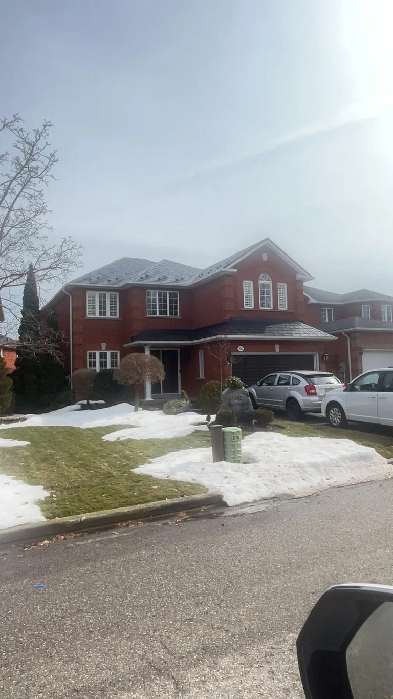 Black Interlock Slate aluminum roof on a red brick home with a two-car garage in a suburban, Mississauga, Ontario