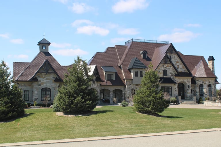 Colonial Brown Interlock Slate aluminum roof on a colonial home with a brown metal roof and stone facade in, Caledon, Ontario