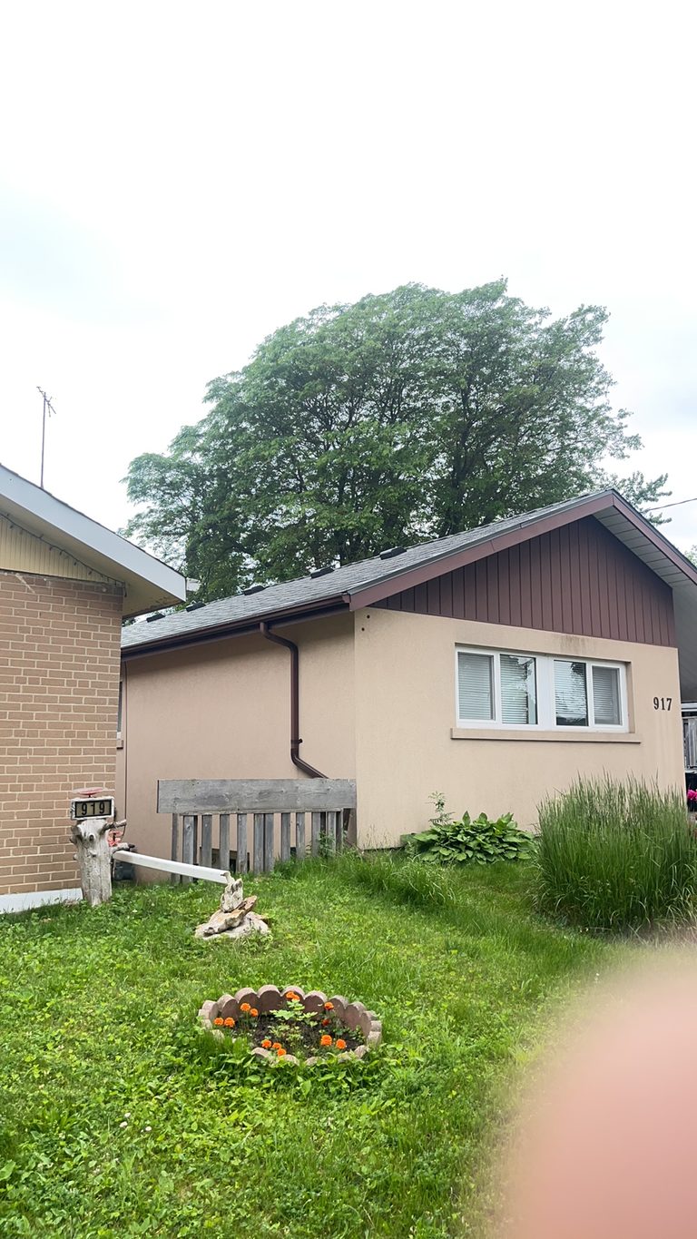 Single-storey ranch home at 917 with Interlock Musket Grey aluminum slate roofing on a simple gable, stucco exterior, Scarborough ON.