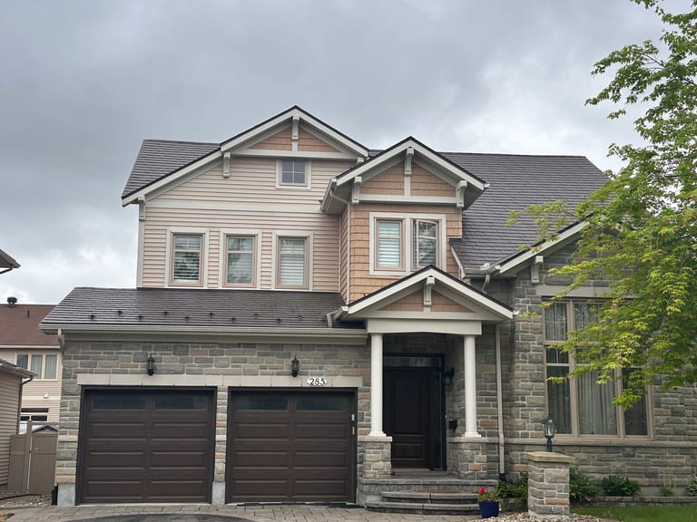 Two-storey Craftsman home in Ottawa with Interlock Tudor Brown aluminum slate metal roofing, stone facade, double garage, and decorative dormers.