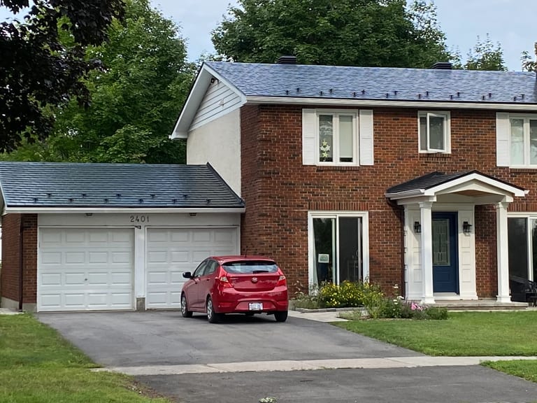 Black Interlock Slate aluminum roof on a brick two-storey home with a metal roof in a suburban area, Ottawa, Ontario