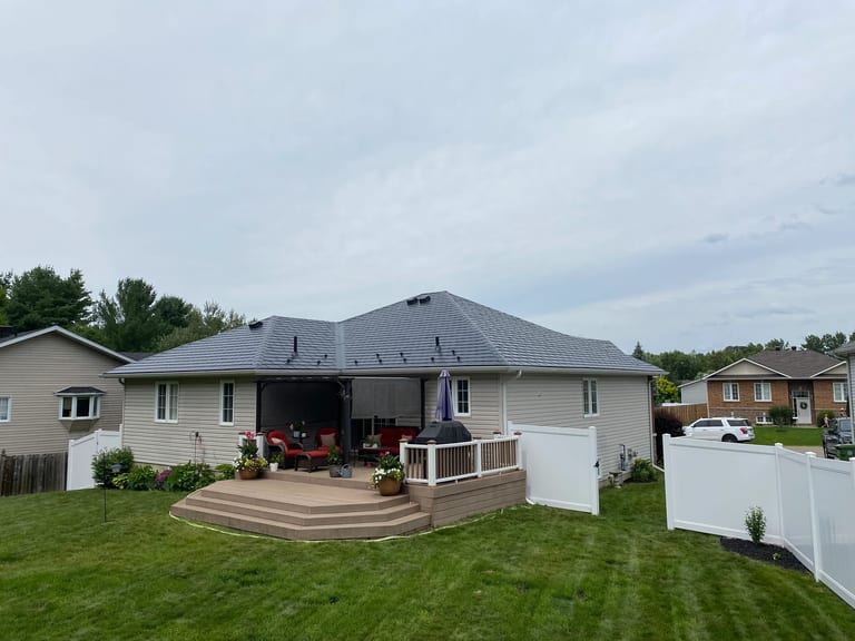 Black Interlock Slate aluminum roof on a house with a grey roof and beige siding in a rural, Pembroke, Ontario