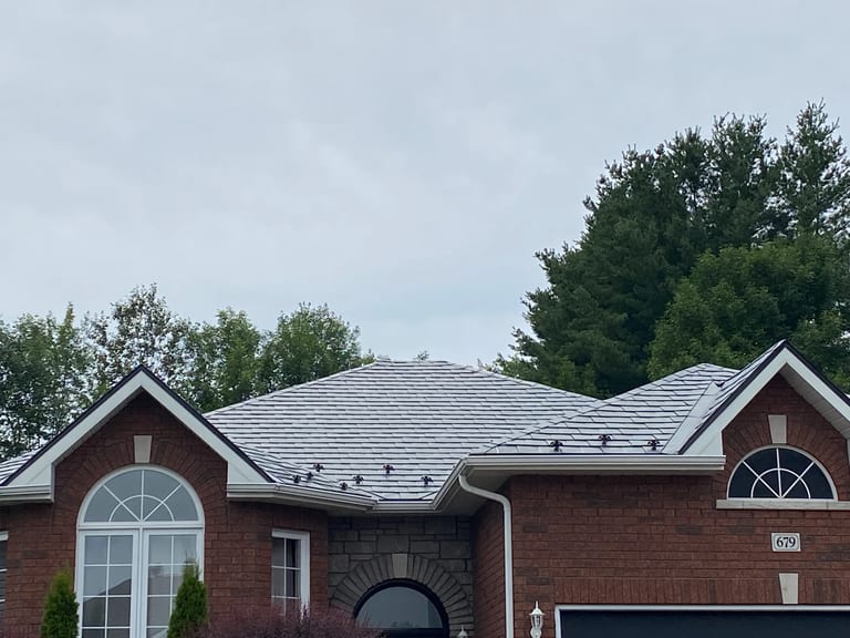 Black Interlock Slate aluminum roof on a red brick single-family home with a metal roof in rural, Pembroke, Ontario
