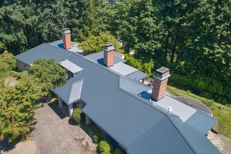 After: Deep Charcoal Interlock Slate aluminum roof on a single-storey home with a metal roof in a forested setting, Portland, Oregon