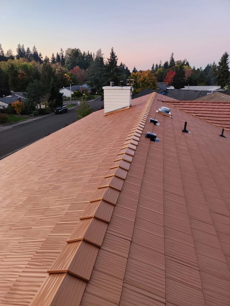 Aerial ridge-line view of Interlock aluminum shake roof in Copper Penny on a suburban ranch home in Salem, OR at golden hour.
