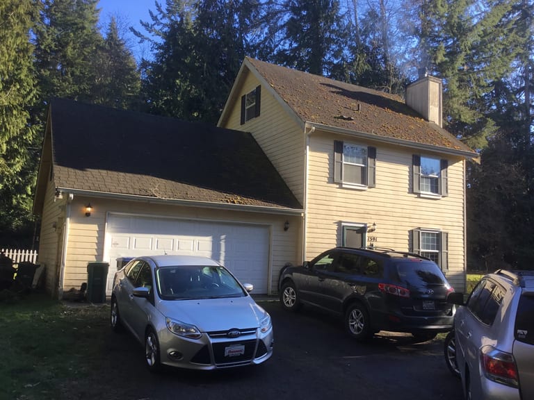 Before: Before: a worn out asphalt shingle roof on the home, Poulsbo, Washington, ahead of a Black Interlock Slate aluminum roof