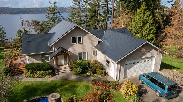 Black Interlock Slate aluminum roof on a light-colored home with a metal roof on a forested, Langley, Washington