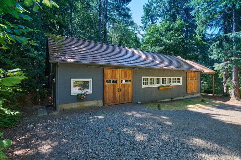 Colonial Brown Interlock Shake aluminum roof on a Colonial brown metal roof on a gray house in a forested, Gig Harbor, Washington