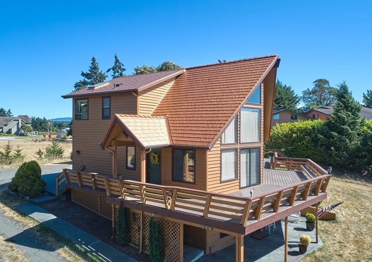 Copper Penny Interlock Cedar Shingle aluminum roof on a two-storey chalet with a copper penny metal roof among, Sequim, Washington