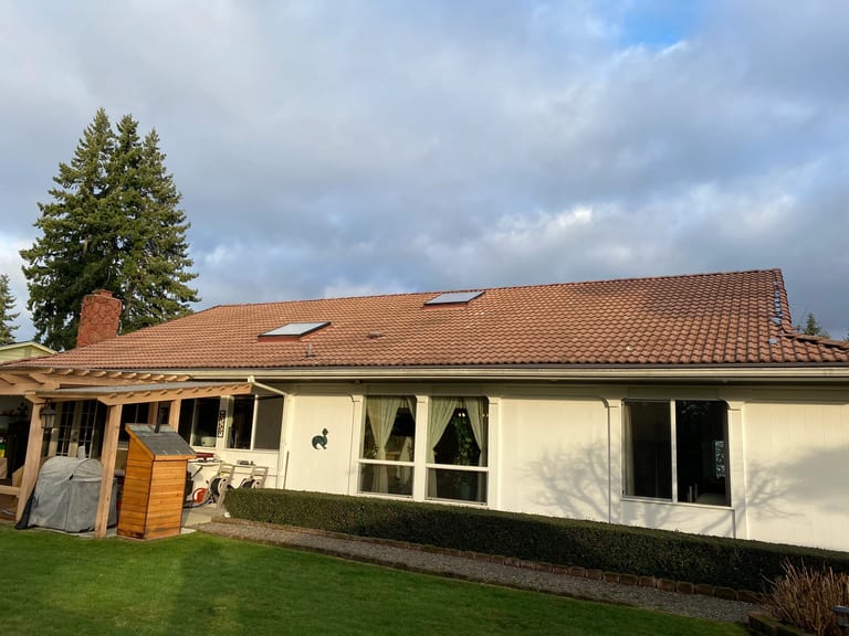 Before: Before: a worn out concrete tile roof on the home, Lakewood, Washington, ahead of a Tile Red Interlock Slate aluminum roof