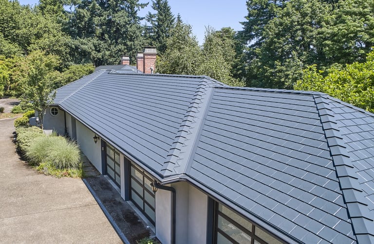 Interlock Metal Roofing installed on a two-story traditional home in Deep Charcoal, showcasing steep-pitch architectural lines and dormer detailing.
