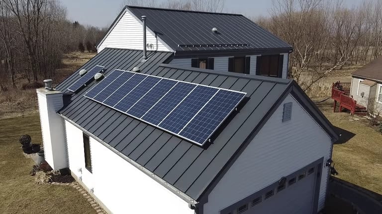 Solar panels mounted on a Deep Charcoal Interlock standing seam aluminum roof in Carpentersville, Illinois — clamped to the seams with no roof penetrations