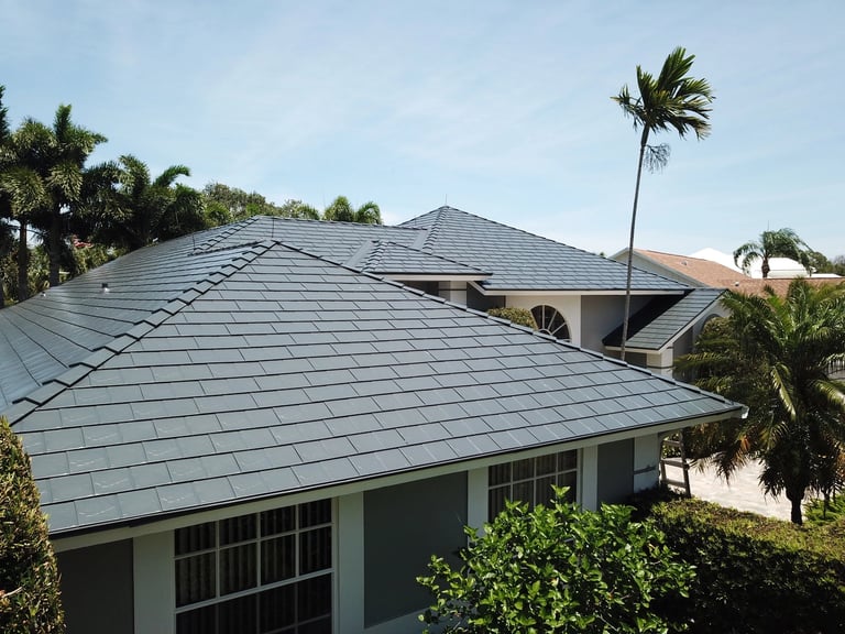 Interlock slate-profile metal roof on a home with palm trees