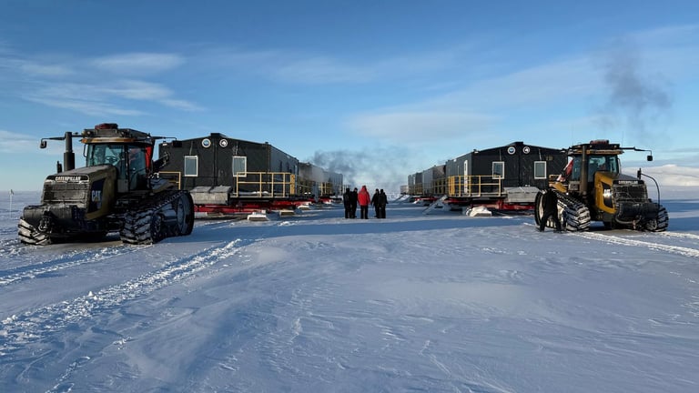 Interlock-clad Antarctic research modules on snow with tracked tractors and expedition personnel