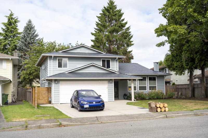 Deep Charcoal Interlock Slate aluminum roof on a two-storey home with a metal roof in a suburban forest, Richmond, British Columbia
