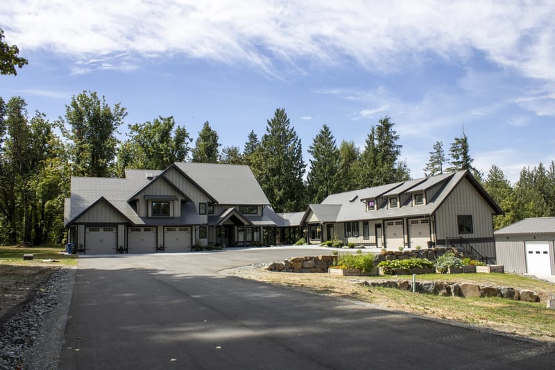 Musket Grey Interlock Slate aluminum roof on a grey modern home with dormers in a forested rural setting, Abbotsford, British Columbia