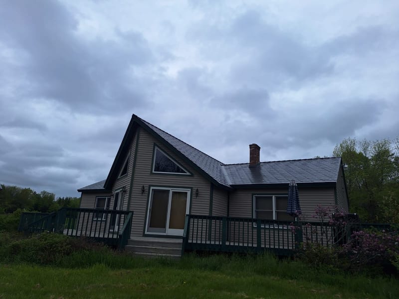 Deep Charcoal Interlock Slate metal roofing on a home in Stetson, Maine.