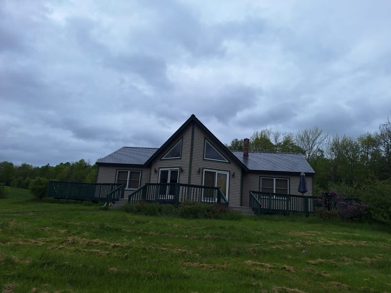 Deep Charcoal Interlock Slate metal roof on a home in Stetson, Maine.