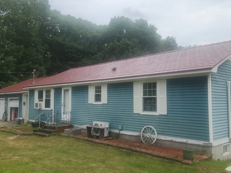 Tile Red Interlock Slate aluminum metal roof on a blue Maine home