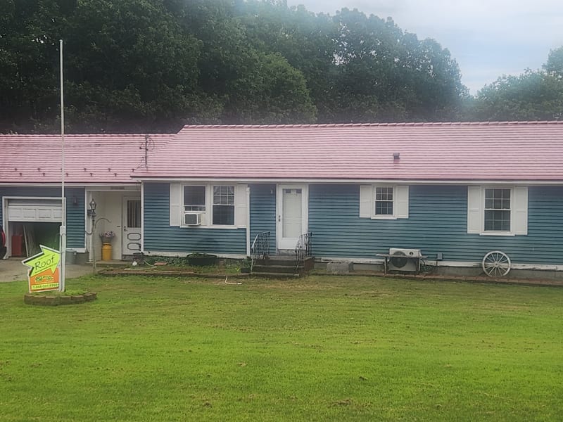 Tile Red Interlock aluminum roof installation on a blue home in Lebanon, Maine