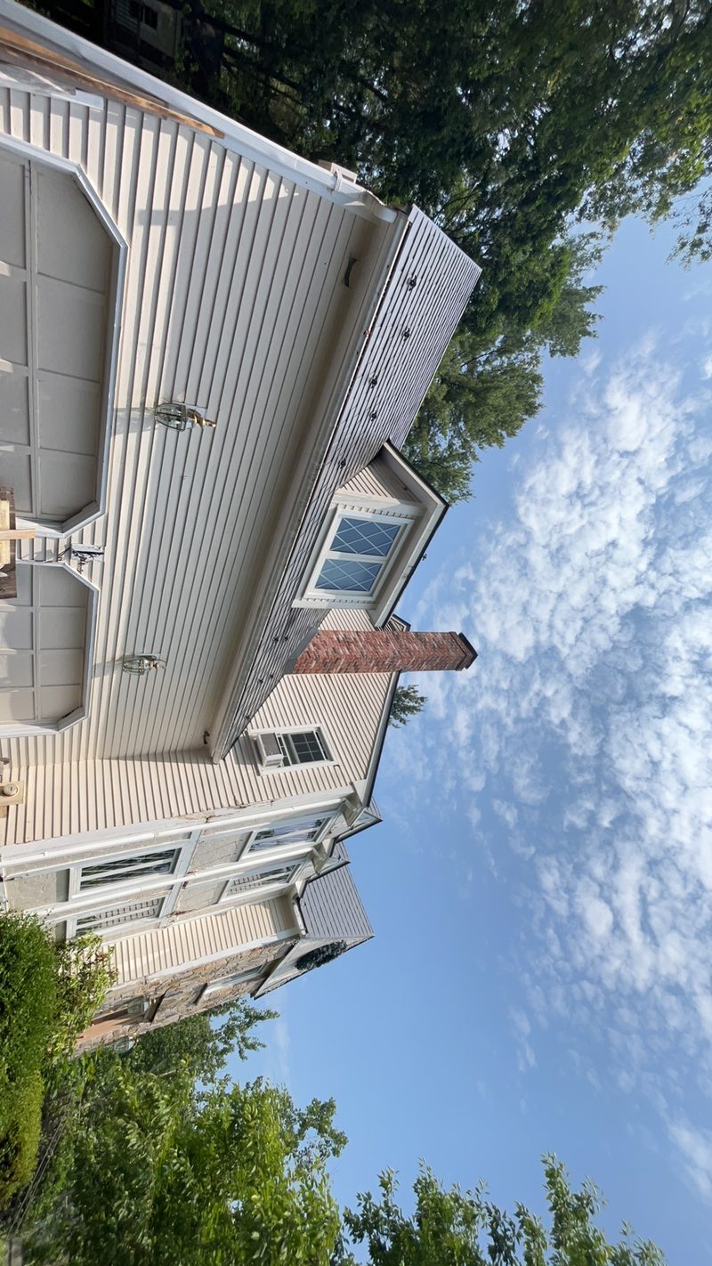 Charcoal Grey Interlock Slate metal roofing installation in Norfolk, MA, with concealed fasteners and a