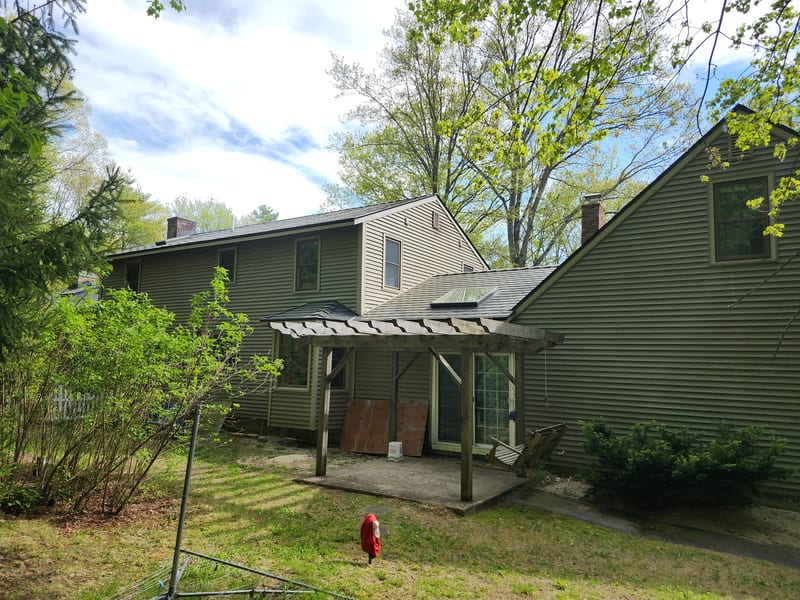 Black Interlock slate aluminum metal roof on a Rochester, NH home with a pergola.