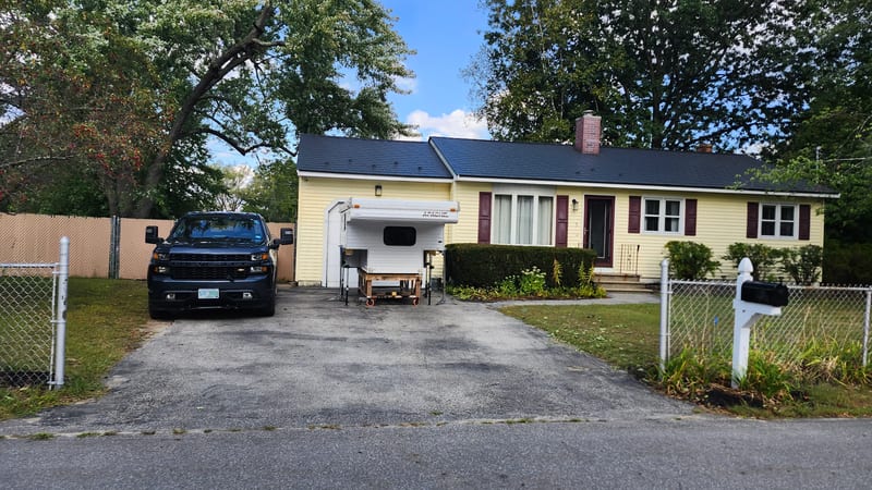 Black Interlock Slate aluminum metal roof on a Bedford, NH home with a truck and
