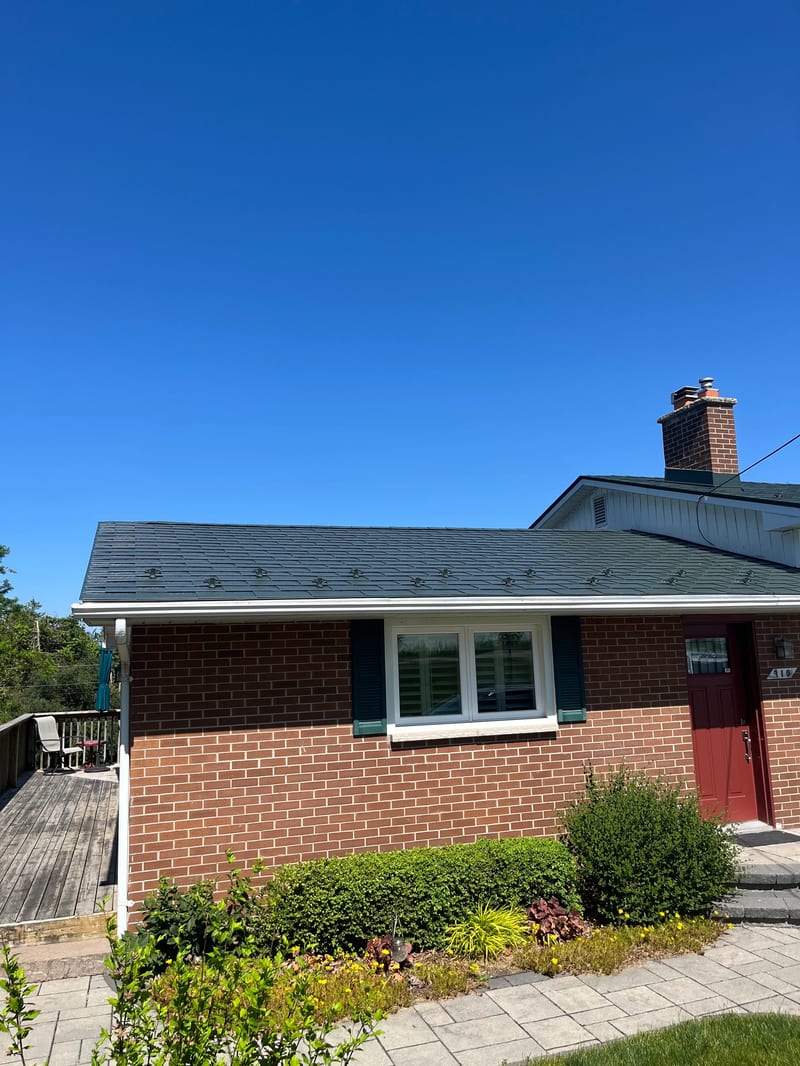 Hunter Green Interlock Shingle aluminum roof on a brown brick home with dormers in a suburban rural setting, Beaverton, Ontario