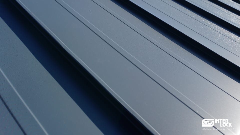 Close-up of Interlock® Standing Seam metal roofing panels — vertical-rib architectural profile in aluminum